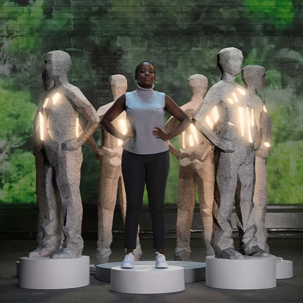 Woman standing among several statues